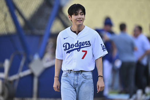 V, a member of the South Korean K-pop band BTS, looks on during batting practice before a baseball game between the Los Angeles Dodgers and the Cincinnati Reds Monday, Aug. 25, 2025, in Los Angeles. (AP Photo/Jayne Kamin-Oncea)