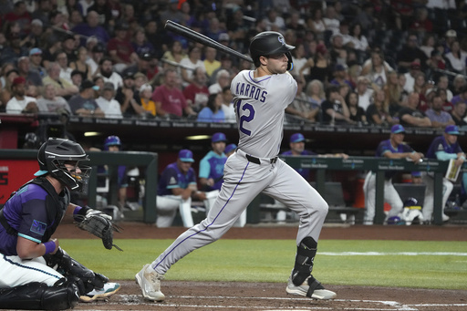 Colorado Rockies' Kyle Karros hits an RBI single on his major league at-bat debut against the Arizona Diamondbacks in the second inning of a baseball game, Friday, Aug. 8, 2025, in Phoenix. (AP Photo/Rick Scuteri)