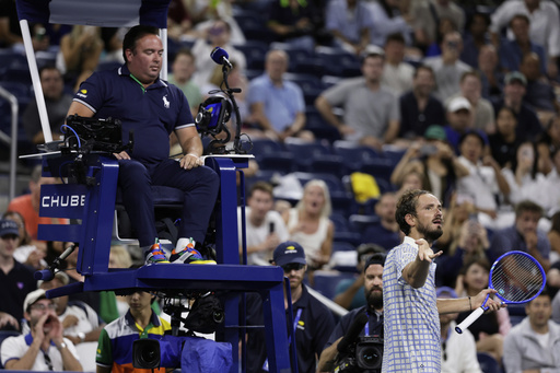 Daniil Medvedev, of Russia, bottom right, reacts next to chair umpire, Greg Allensworth, left, after a photographer ran onto the court during a match against Benjamin Bonzi, of France, in the first-round of the U.S. Open tennis championships, Sunday, Aug. 24, 2025, in New York. (AP Photo/Adam Hunger)