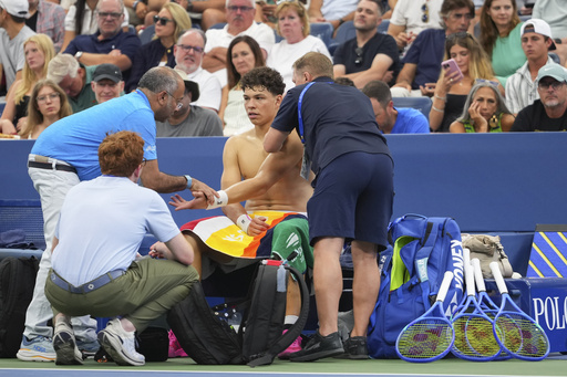 Trainers work on Ben Shelton, of the United States, during a break in play against Adrian Mannarino, of France, during the third round of the U.S. Open tennis championships, Friday, Aug. 29, 2025, in New York. (AP Photo/Kirsty Wigglesworth)
