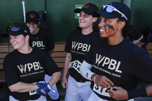 Lauren Boden, second from right, Stephanie Everett, right, and other players talk in the dugout during the first day of tryouts for the Women's Professional Baseball League, Friday, Aug 22, 2025, at the Washington Nationals Youth Baseball Academy in Washington. (AP Photo/Julia Demaree Nikhinson)