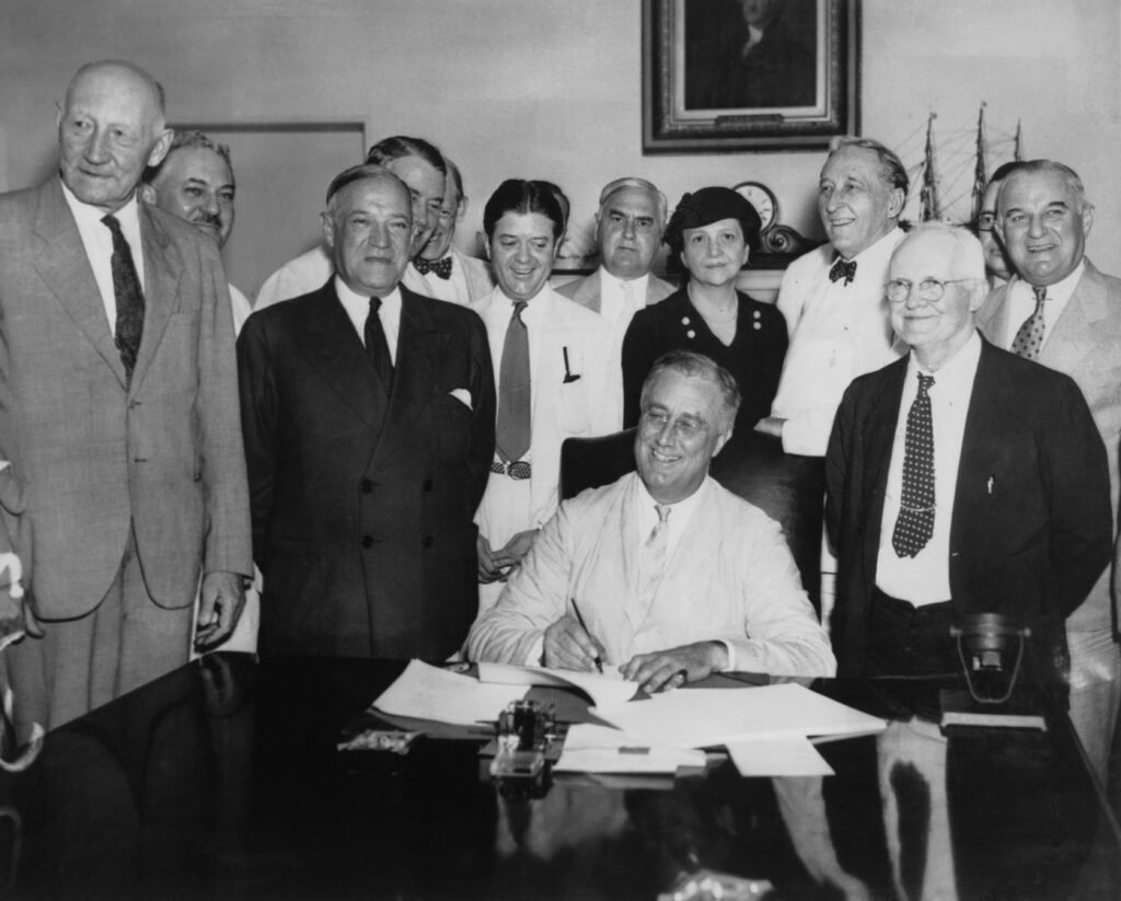 President Franklin D. Roosevelt signs the Social Security Act on Aug. 14, 1935. (Photo by FPG/Archive Photos/Getty Images)