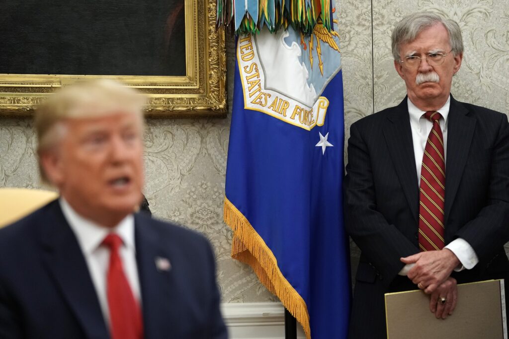 Then-White House National Security Advisor John Bolton (R) listens to President Donald Trump as he and Dutch Prime Minister Mark Rutte talk to reporters in the Oval Office at the White House July 18, 2019. (Photo by Chip Somodevilla/Getty Images)