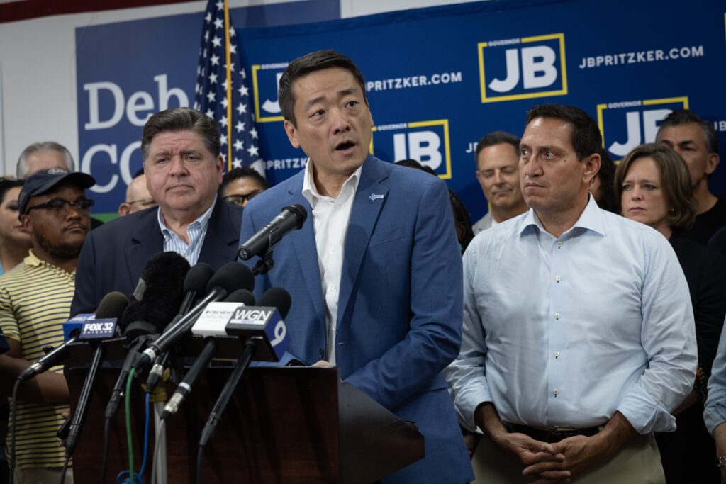 Illinois Governor JB Pritzker, left, and Texas Rep. Trey Martinez Fischer, right, listen as Texas House Democratic Caucus Chair Gene Wu speaks to reporters during a press conference at the DuPage County Democratic Party headquarters on Aug. 3, 2025 in Carol Stream, Illinois. Wu was with a group of Democratic Texas lawmakers who left the state so a quorum could not be reached during a special session called to redistrict the state. (Photo by Scott Olson/Getty Images)