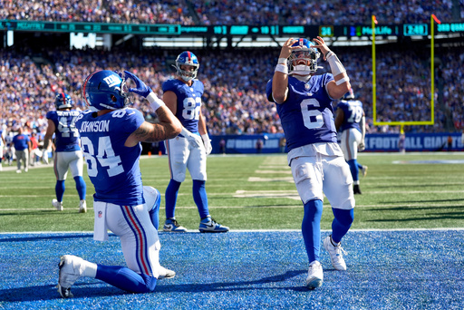 New York Giants tight end Theo Johnson (84) and quarterback Jaxson Dart (6) celebrate after Johnson scored a touchdown against the Los Angeles Chargers during the third quarter of an NFL football game, Sunday, Sept. 28, 2025, in East Rutherford, N.J. (AP Photo/Yuki Iwamura)