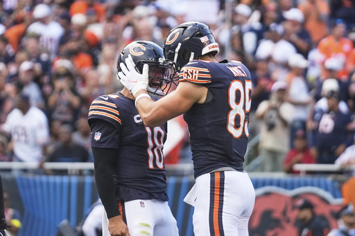 Chicago Bears' Caleb Williams (18) and Cole Kmet (85) celebrate after Kmet caught a touchdown pass in the first half of an NFL football game against the Dallas Cowboys Sunday, Sept. 21, 2025, in Chicago. (AP Photo/Erin Hooley)