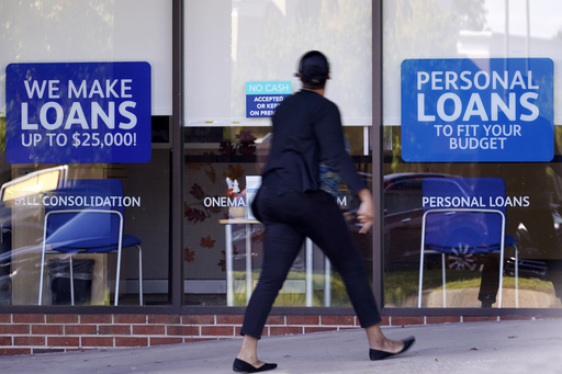 FILE - A woman walks past a personal finance loan office Thursday, Oct. 1, 2020, in Franklin, Tenn. (AP Photo/Mark Humphrey, File)