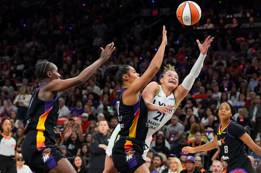 Phoenix Mercury forward Satou Sabally, center, fouls Minnesota Lynx guard Kayla McBride (21) during the first half of Game 4 of a WNBA basketball playoff semifinals series, Sunday, Sept. 28, 2025, in Phoenix. (AP Photo/Samantha Chow)
