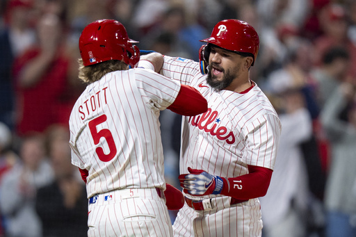 Philadelphia Phillies' Kyle Schwarber, right, reacts to his three-run home run with Bryson Stott, left, during the seventh inning of a baseball game against the New York Mets, Tuesday, Sep. 9, 2025, in Philadelphia. (AP Photo/Chris Szagola)