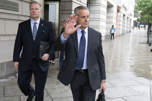 Retired Adm. Robert P. Burke, 63, right, accompanied by his attorney, walks out of the federal courthouse after being sentenced to six years in prison for his conviction on corruption charges, Tuesday, Sept. 16, 2025, in Washington. (AP Photo/Jose Luis Magana)
