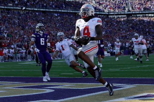 Ohio State wide receiver Jeremiah Smith (4) scores on a pass run play against the Washington during the first half of an NCAA college football game, Saturday, Sept. 27, 2025, in Seattle. (AP Photo/John Froschauer)