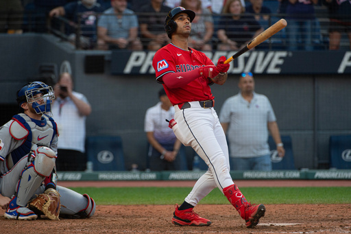 Cleveland Guardians' Brayan Rocchio, right, watches his walk off three-run home run off Texas Rangers relief pitcher Jose Corniell as Jonah Heim, left, watches during the tenth inning of a baseball game, Sunday, Sept. 28, 2025, in Cleveland. (AP Photo/Phil Long)