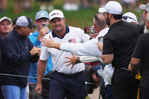 Fans greets United States' Bryson DeChambeau on the 17th hole during a practice round at the Ryder Cup golf tournament, Thursday, Sept. 25, 2025, on the Bethpage Black golf course, in Farmingdale, N.Y. (AP Photo/Matt Slocum)