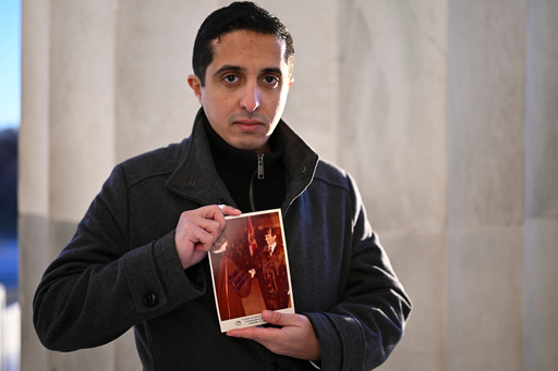 FILE - Ibrahim Almadi holds a photo of his father Saad Almadi graduating from college in 1984, in Washington, Dec. 23, 2024. (AP Photo/John McDonnell, File)