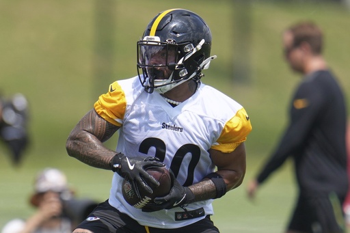 FILE - Pittsburgh Steelers running back Jaylen Warren quarterback Will Howard throws a pass during the NFL football team's training camp in Latrobe, Pa., July 24, 2025. (AP Photo/Gene J. Puskar, File)