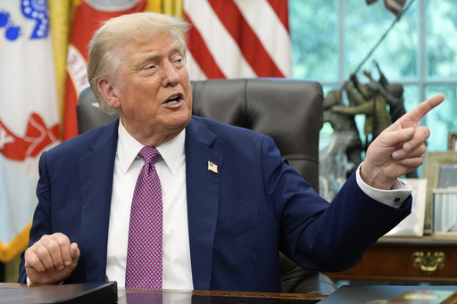 President Donald Trump point to a G20 Miami 2026 poster as he speaks in the Oval Office of the White House, Friday, Sept. 5, 2025, in Washington. (AP Photo/Alex Brandon)