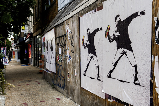 Posters of a person throwing a sandwich are pictured along H Street, Sunday, Aug. 17, 2025, in Washington. (AP Photo/Julia Demaree Nikhinson)