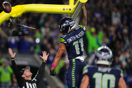 Seattle Seahawks wide receiver Jaxon Smith-Njigba (11) celebrates his touchdown catch as an official signals and looks on in the first half of an NFL football game Monday, Oct. 20, 2025, in Seattle. (AP Photo/Lindsey Wasson)