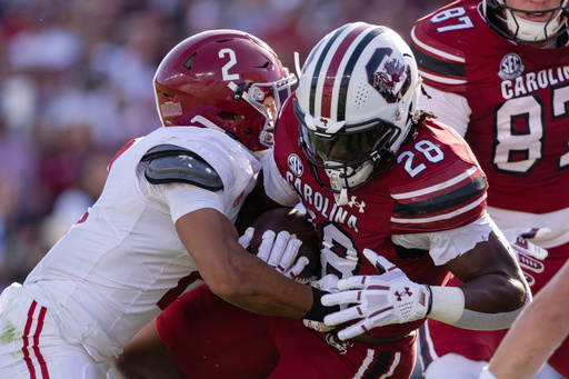Alabama defensive back Zabien Brown (2) tackles South Carolina running back Matt Fuller (28) during the first half of an NCAA college football game, Saturday, Oct. 25, 2025, in Columbia, S.C. (AP Photo/Scott Kinser)