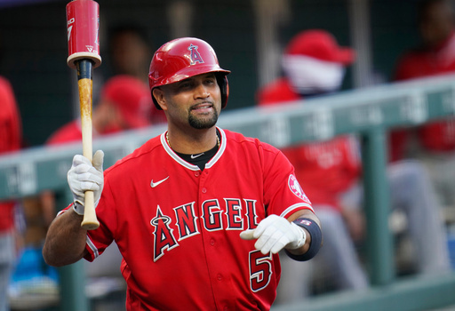 FILE - Los Angeles Angels designated hitter Albert Pujols waves to players in the Colorado Rockies dugout in the second inning of a baseball game, Sept. 12, 2020, in Denver. (AP Photo/David Zalubowski, File)