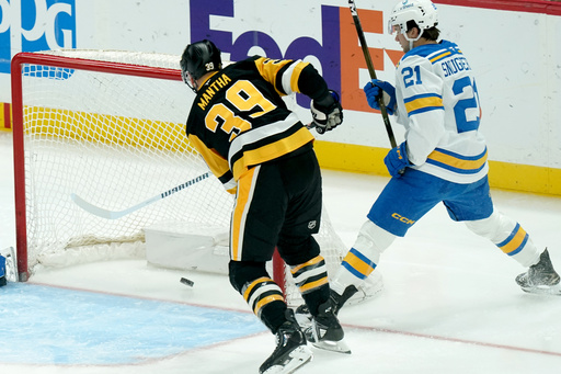 Pittsburgh Penguins' Anthony Mantha (39) scores next to St. Louis Blues' Jimmy Snuggerud (21) during the first period of an NHL hockey game, Monday, Oct. 27, 2025, in Pittsburgh. (AP Photo/Matt Freed)