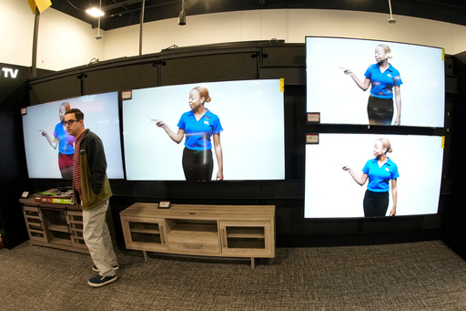FILE - A customer turns away after looking at big-screen televisions on display in a Best Buy store, Nov. 21, 2023, in southeast Denver. (AP Photo/David Zalubowski, file)