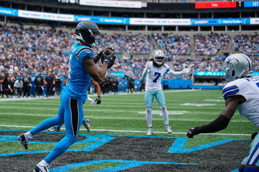 Carolina Panthers wide receiver Tetairoa McMillan (4) catches a touchdown pass in front of Dallas Cowboys' Trevon Diggs (7) and Donovan Wilson, right, in the second half of an NFL football game, Sunday, Oct. 12, 2025, in Charlotte, N.C. (AP Photo/Jacob Kupferman)
