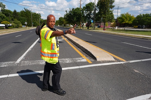 School crossing guard Anthony Taylor directs students on when to cross the street, Wednesday, Sept. 3, 2025, in Indianapolis. (AP Photo/Darron Cummings)