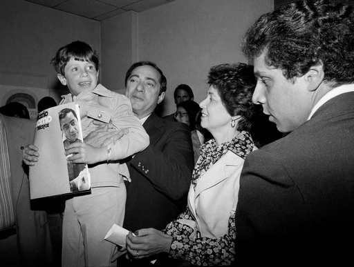 FILE — In this 1977 file photo, New York Secretary of State Mario Cuomo, holds up his son, Christopher, 6, during a press conference as his wife Matilda, center, and son Andrew, 19, right, look on, during his run for mayor of New York City. (AP Photo, File)