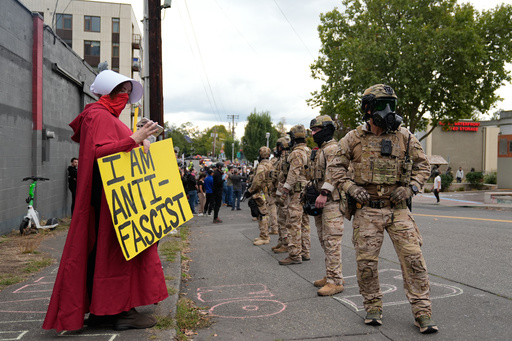 Customs and Border Protection agents standoff against demonstrators outside a U.S. Immigration and Customs Enforcement facility during a protest on Saturday, Oct. 4, 2025, in Portland, Ore. (AP Photo/Jenny Kane)