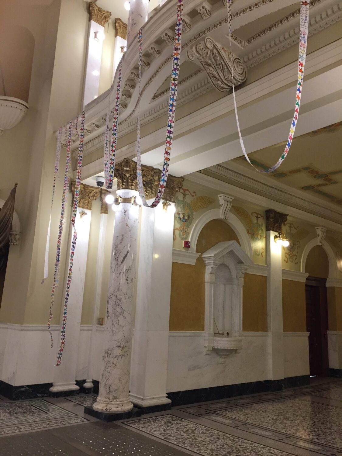 Protesters put 4,321 paper dolls on display on Oct. 14, 2025, in the South Dakota Capitol, representing the number of children affected by the state’s funding reduction for a program benefiting low-income families. (Courtesy of Cathy Brechtelsbauer)