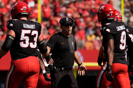 Cincinnati Bearcats head coach Scott Satterfield greets players on the field during the first half of an NCAA college football game against Iowa State , Saturday, Oct. 4, 2025, in Cincinnati. (AP Photo/Carolyn Kaster)