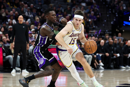Los Angeles Lakers guard Austin Reaves (15) drives to the basket with Sacramento Kings guard Dennis Schröder, left, defending during the second half of an NBA basketball game Sunday, Oct. 26, 2025, in Sacramento, Calif. (AP Photo/Sara Nevis)