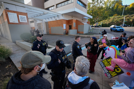 Law enforcement officers talk with protesters outside a United States Immigration and Customs Enforcement (ICE) facility in Portland, Ore., Monday, Oct. 20, 2025. (AP Photo/Jenny Kane)