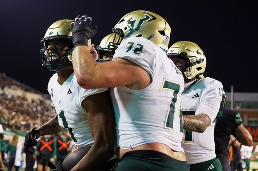 South Florida tight end Johnathan Echols celebrates a touchdown with Cole Best (72) and quarterback Byrum Brown (17) against North Texas in an NCAA college football game Friday, Oct. 10, 2025, in Denton, Texas. (AP Photo/Richard W. Rodriguez)