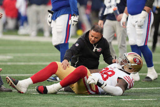 San Francisco 49ers defensive end Mykel Williams (98) is helped by an athletic trainer during the fourth quarter of an NFL football game against the New York Giants, Sunday, Nov. 2, 2025, in East Rutherford, N.J. (AP Photo/Frank Franklin II)