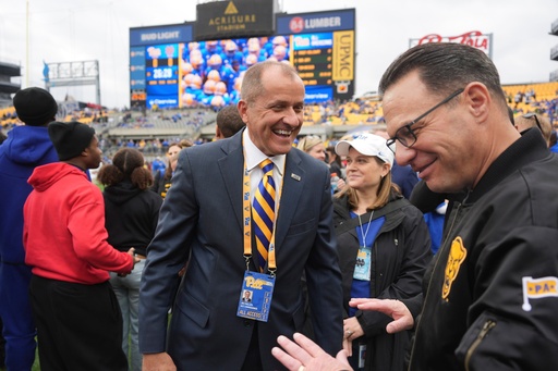 ACC Commissioner Jim Phillips, center, visits with Pennsylvania Governor Josh Shapiro, right, on the field before an NCAA college football game between Pittsburgh and Notre Dame in Pittsburgh, Nov. 15, 2025. (AP Photo/Gene J. Puskar)