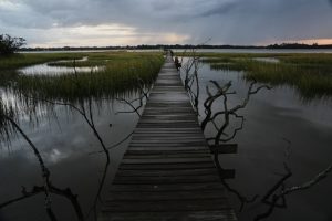 A storm moves through a salt marsh at sunset Monday, Oct. 6, 2025, in Charleston, S.C. (AP Photo/Joshua A. Bickel)