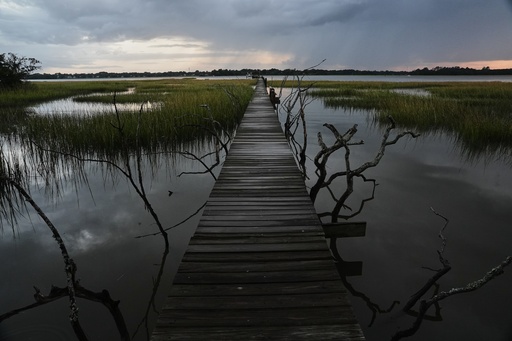 A storm moves through a salt marsh at sunset Monday, Oct. 6, 2025, in Charleston, S.C. (AP Photo/Joshua A. Bickel)