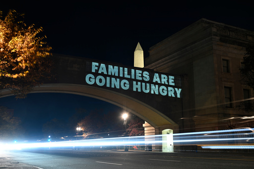 A message from the National Women's Law Center concerning the announcement by the Trump administration of restoring only half funding the SNAP benefits is projected on the U.S. Department of Agriculture building, Monday, Nov. 3, 2025, in Washington. (AP Photo/John McDonnell)