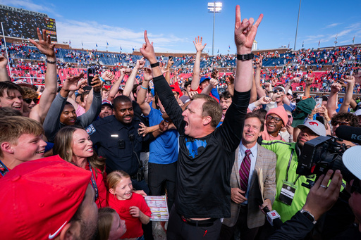 SMU head coach Rhett Lashlee celebrates on the field with fans after his team's 26-20 overtime win over Miami in an NCAA college football game, Saturday, Nov. 1, 2025, in Dallas. (AP Photo/Jeffrey McWhorter)