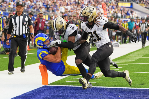 Los Angeles Rams wide receiver Puka Nacua (12) pulls in a touchdown pass against New Orleans Saints cornerback Kool-Aid McKinstry (4) and safety Justin Reid (21) in the first half of an NFL football game Sunday, Nov. 2, 2025, in Inglewood, Calif. (AP Photo/Gregory Bull)