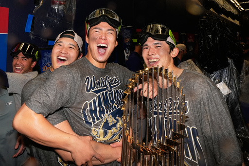 Los Angeles Dodgers pitcher Shohei Ohtani, pitcher Yoshinobu Yamamoto and pitcher Roki Sasaki celebrate after their win against the Toronto Blue Jays in Game 7 of baseball's World Series, Sunday, Nov. 2, 2025, in Toronto. (AP Photo/Brynn Anderson)