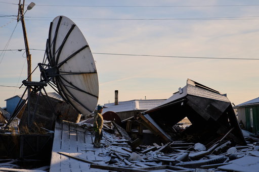 Harry Friend walks among debris caused by the remnants of Typhoon Halong hitting the village and region earlier in the month, Monday, Oct. 27, 2025, in Kwigillingok, Alaska. (AP Photo/Lindsey Wasson)