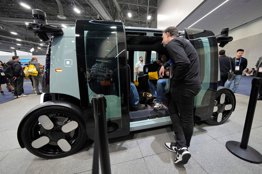 FILE - People view a Zoox self-driving vehicle at the Zoox booth during the CES tech show, Jan. 7, 2025, in Las Vegas. (AP Photo/John Locher, file)