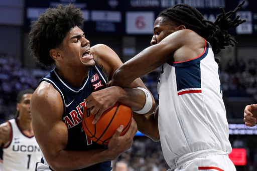 Arizona forward Koa Peat and UConn guard Silas Demary Jr., right, fight for possession of the ball in the first half of an NCAA college basketball game, Wednesday, Nov. 19, 2025, in Storrs, Conn. (AP Photo/Jessica Hill)