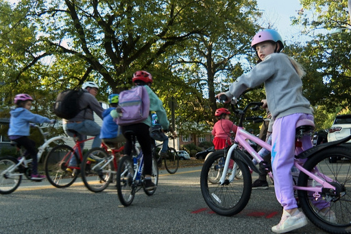 In an image taken from video, children ride their bicycles to school during a parent-led bike ride titled "Bike Bus" Oct. 3, 2025, in Montclair, N.J. (AP Photo/Tassanee Vejpongsa)