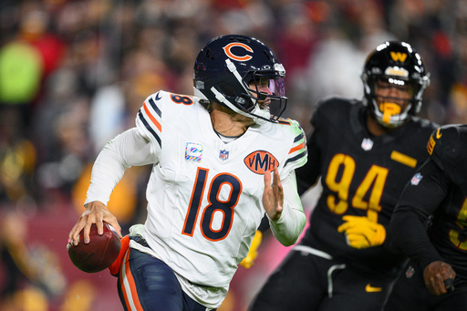 Chicago Bears quarterback Caleb Williams (18) runs away from Washington Commanders nose tackle Daron Payne (94) during the second half of an NFL football game Monday, Oct. 13, 2025, in Landover, Md. (AP Photo/Nick Wass)