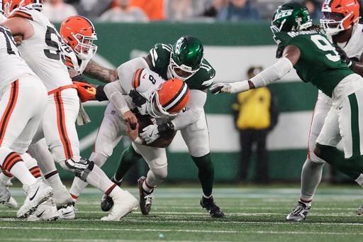 Cleveland Browns quarterback Dillon Gabriel (8) is sacked by New York Jets linebacker Jermaine Johnson (11) in the second half of an NFL football game, Sunday, Nov. 9, 2025, in East Rutherford, N.J. (AP Photo/Adam Hunger)