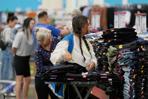 File - A worker stocks a display of clothing at a Sam's Club, Wednesday, Sept. 24, 2025, in Bentonville, Ark. (AP Photo/Charlie Riedel, File)